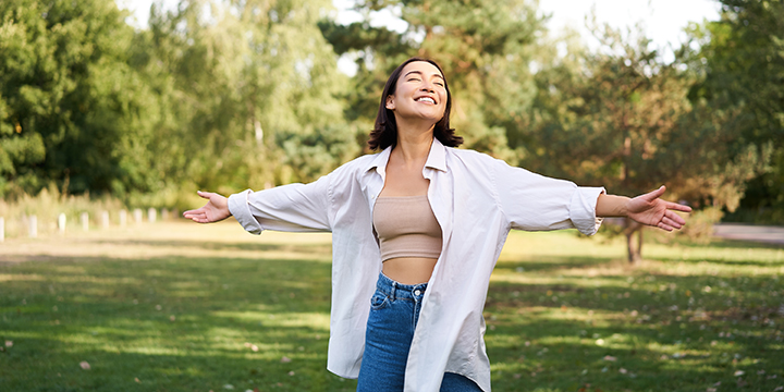carefree asian girl laughing dancing park enjoying summer sunny day raising hands up brea